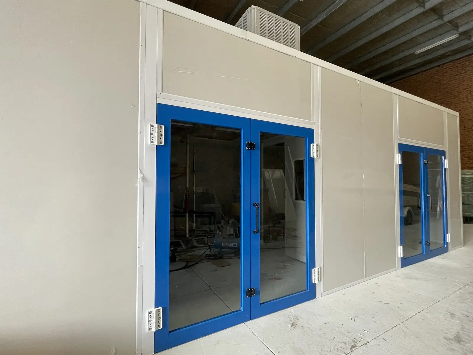 Spray booth with blue-framed service doors